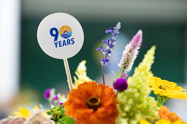 Close-up of the 90th anniversary logo displayed in a floral centerpiece at the United Way of Greater Kingsport anniversary celebration.